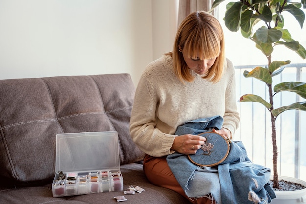 osoba haftująca przy stole